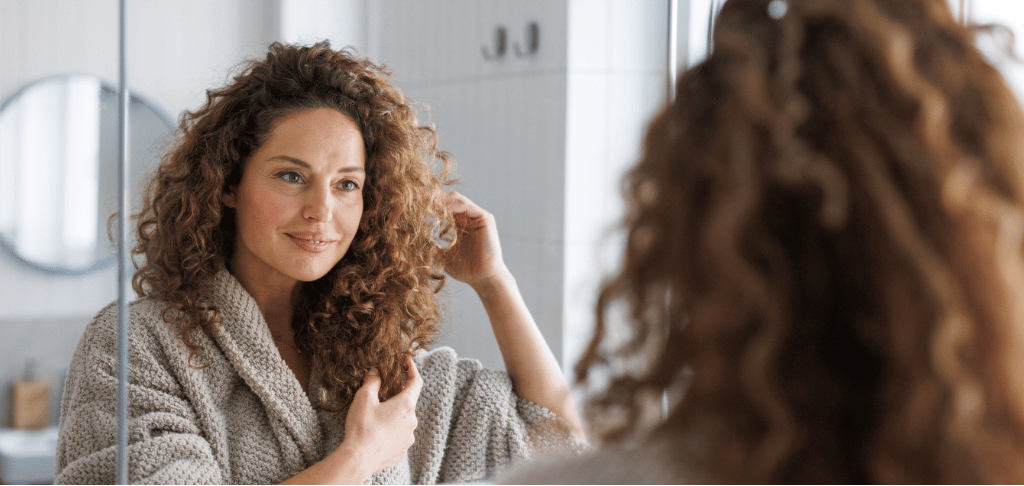 Femme aux cheveux bouclés utilisant la routine capillaire Boucles de LOVEA