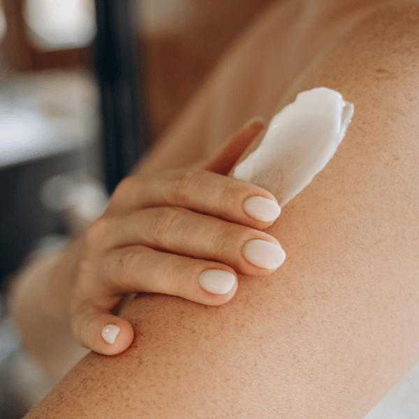Femme s'hydratant les bras avec une crème hydratante
